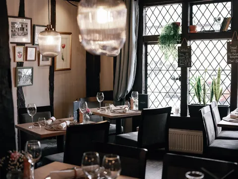 Restaurant tables beside leaded windows and pendant lights