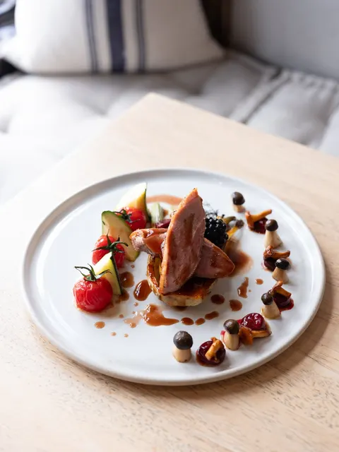Plated meat dish with vegetables and sauce