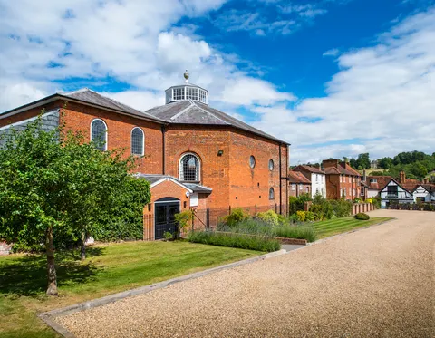 Brick exterior of Kings Chapel beside a garden and gravel path