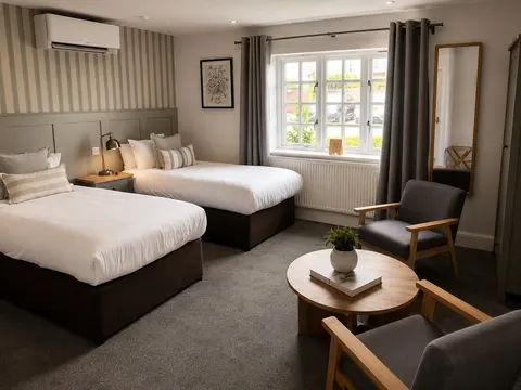 Twin beds and a seating area beside a sash window
