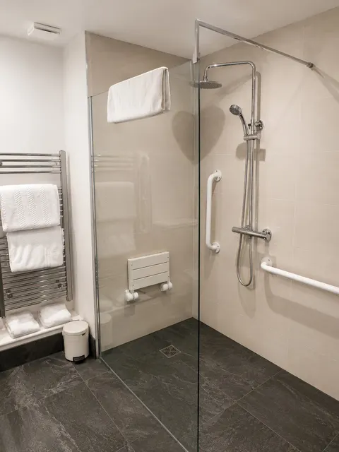 Accessible shower with a fold-down seat and grab rails