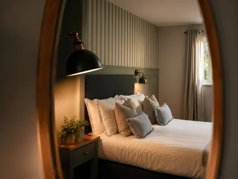 Contemporary bedroom with a double bed, striped wall and bedside lamp