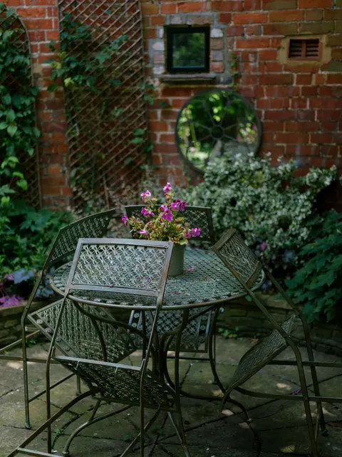 Garden table and chairs beside the brick wall at No. 40