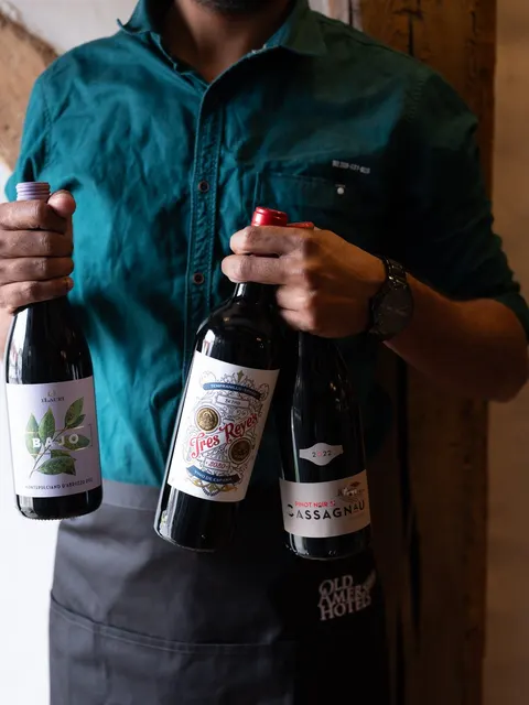 A member of staff holding two bottles of wine